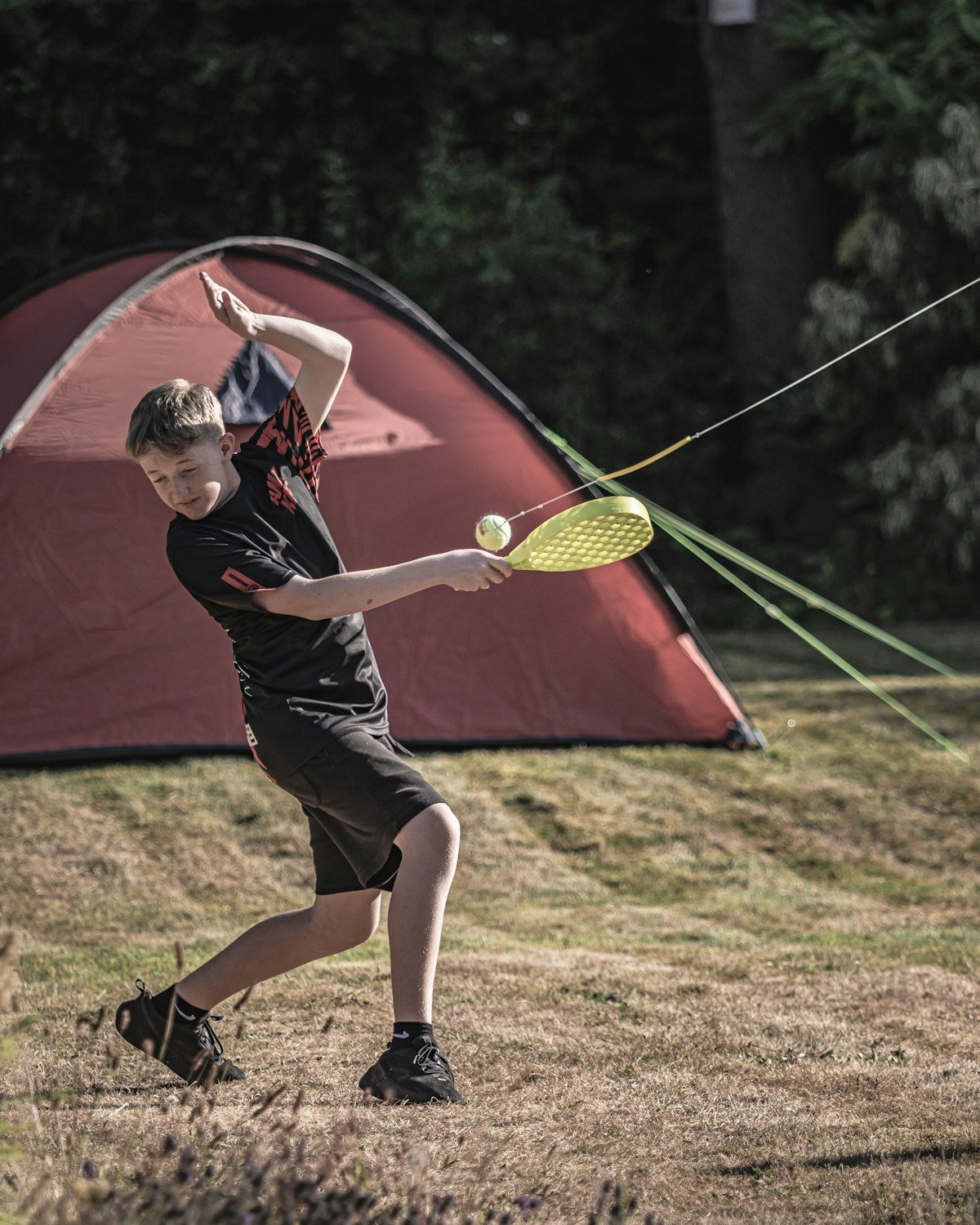 Kid playing outside a backyard camping tent