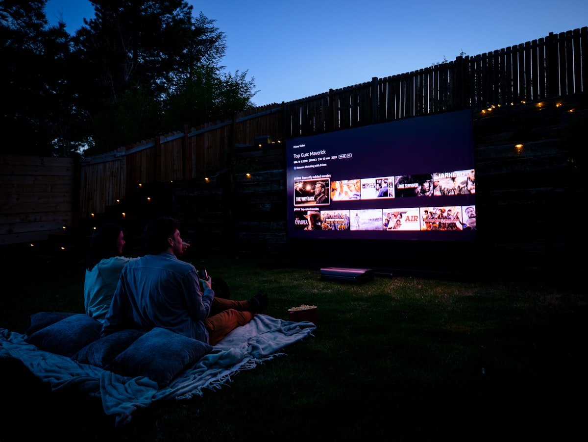 Backyard movie night with a projector screen glowing at dusk
