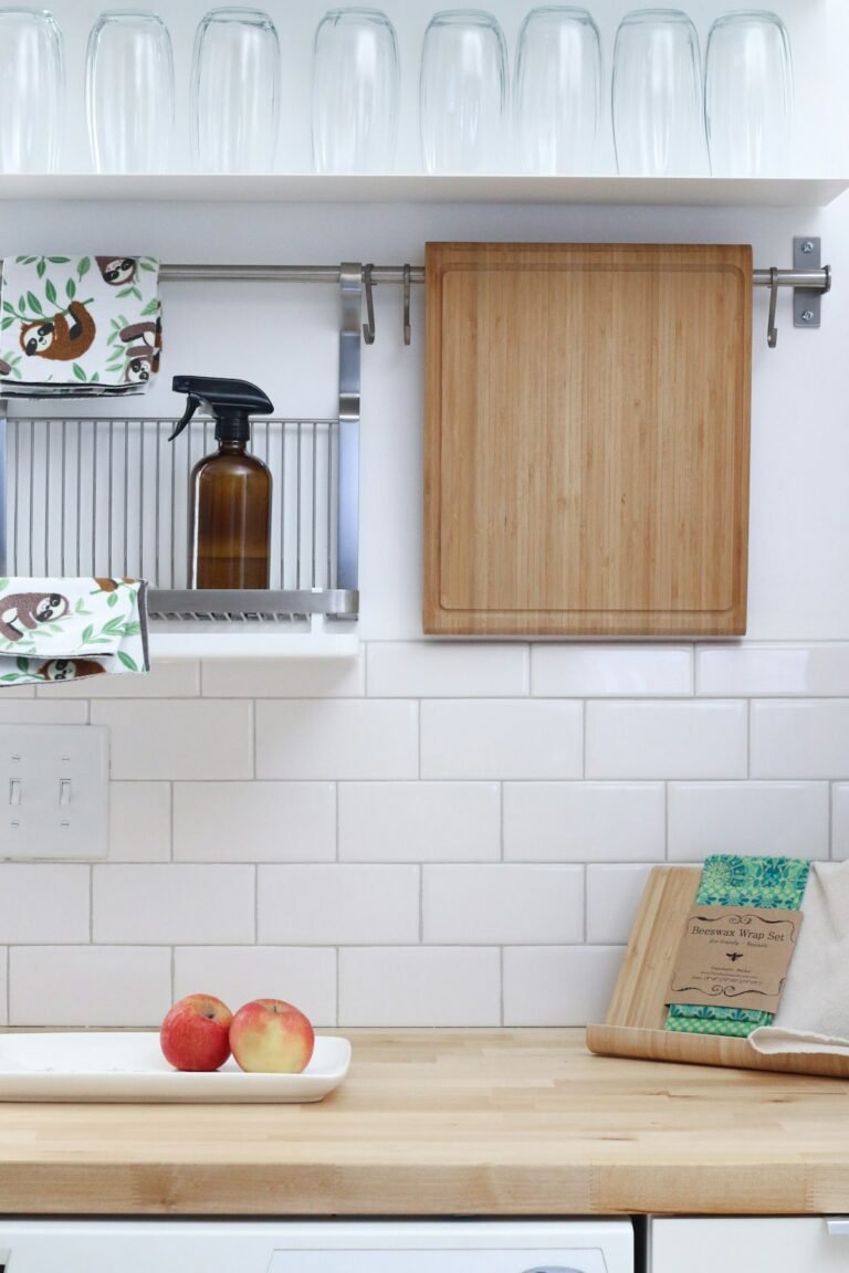 Clean white kitchen counter with subway tile and a simple open shelf