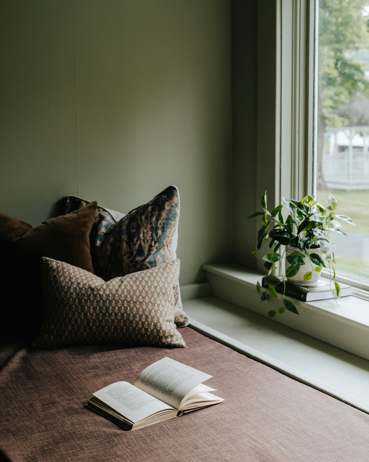 Cozy reading nook chair with pillows by the window