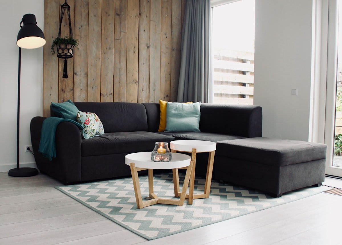 Cozy small living room with sectional sofa, rug, and warm wood wall