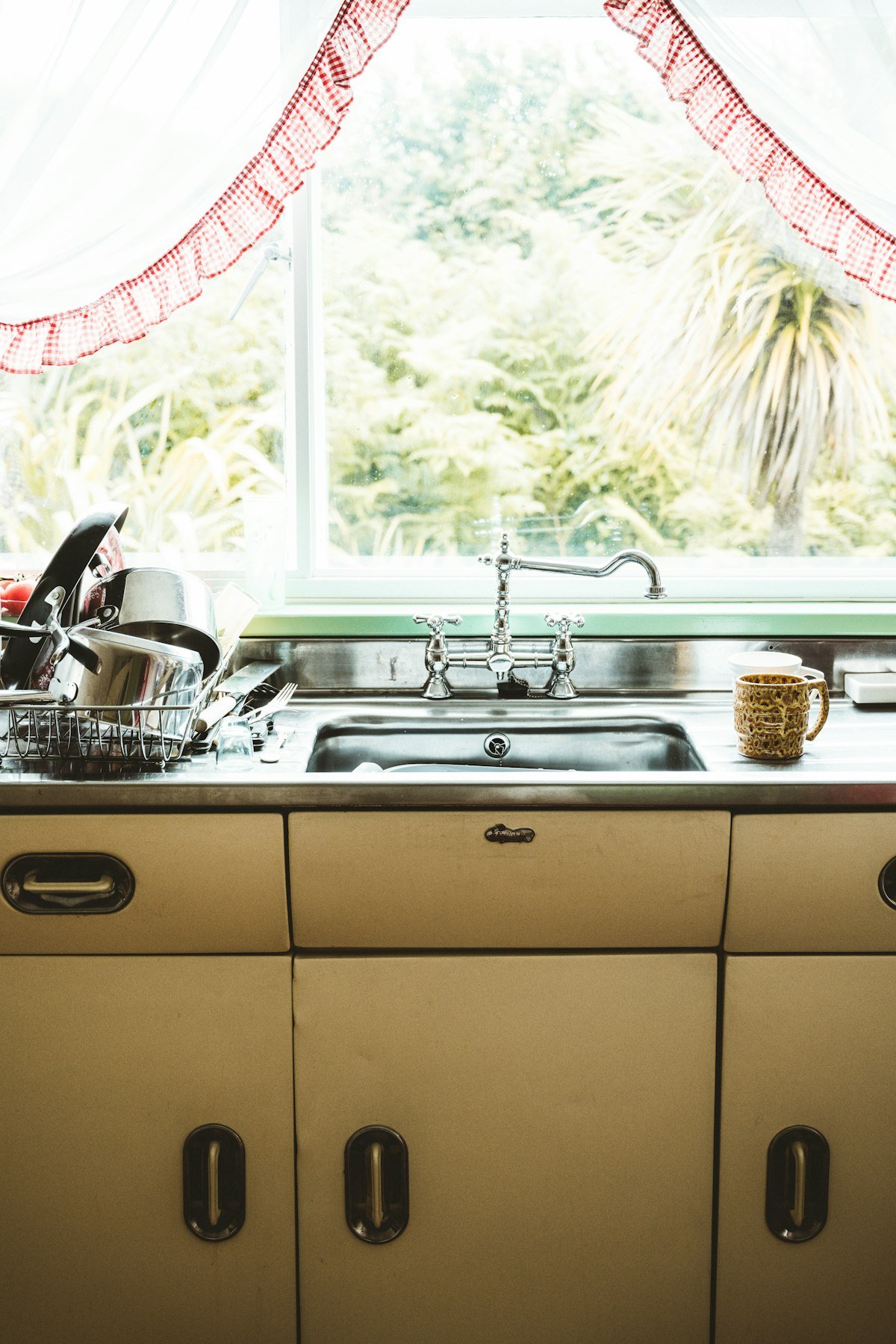 Dish rack drying dishes beside a kitchen sink window