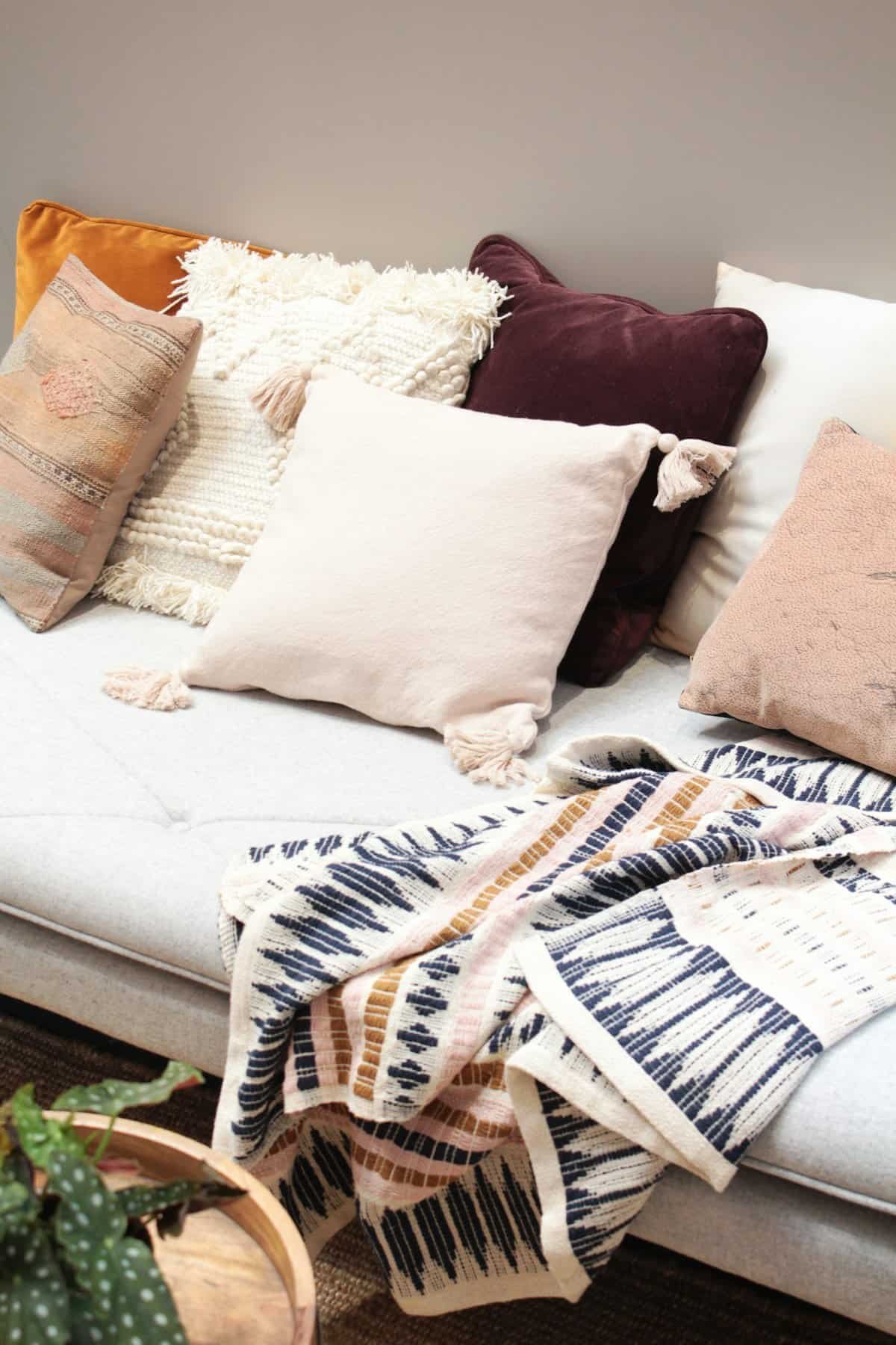 Rust and cream fall pillow covers styled on a neutral couch
