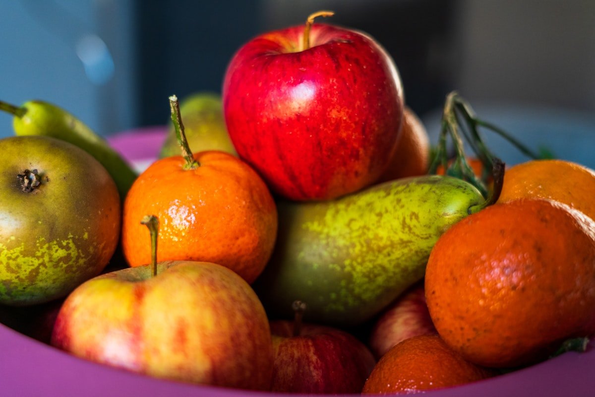 Bowl piled with oranges, pears, and apples as an edible centerpiece