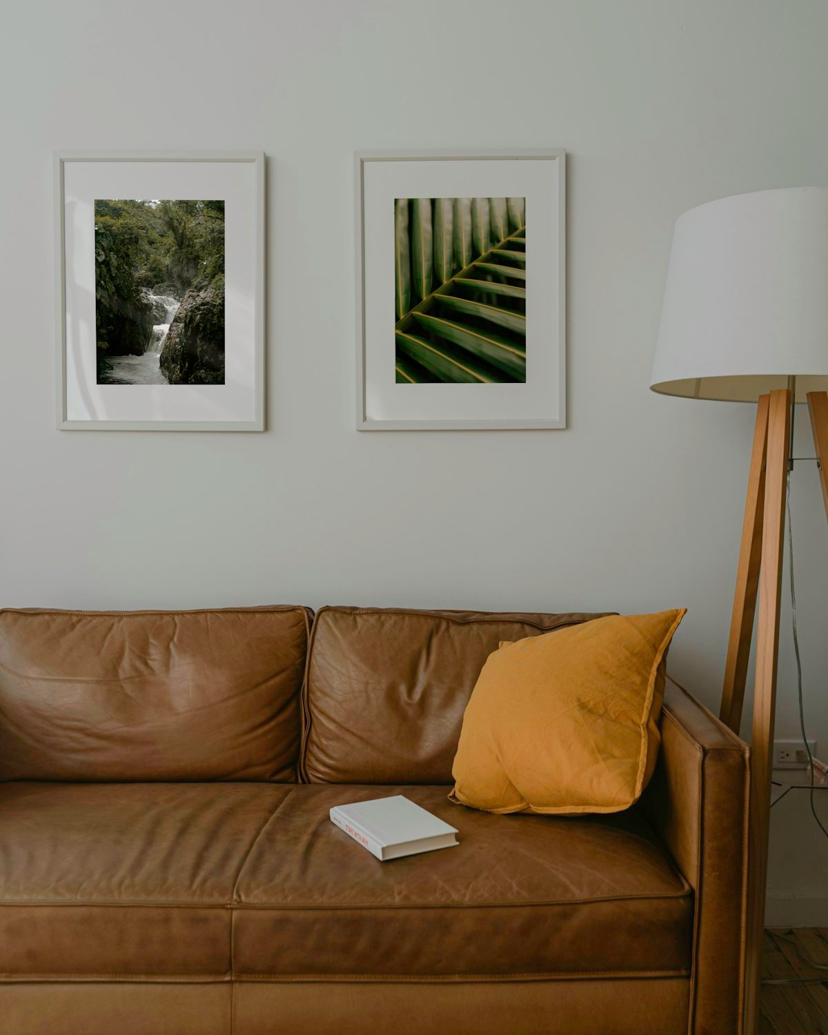 Framed prints hung as a gallery wall above an apartment couch