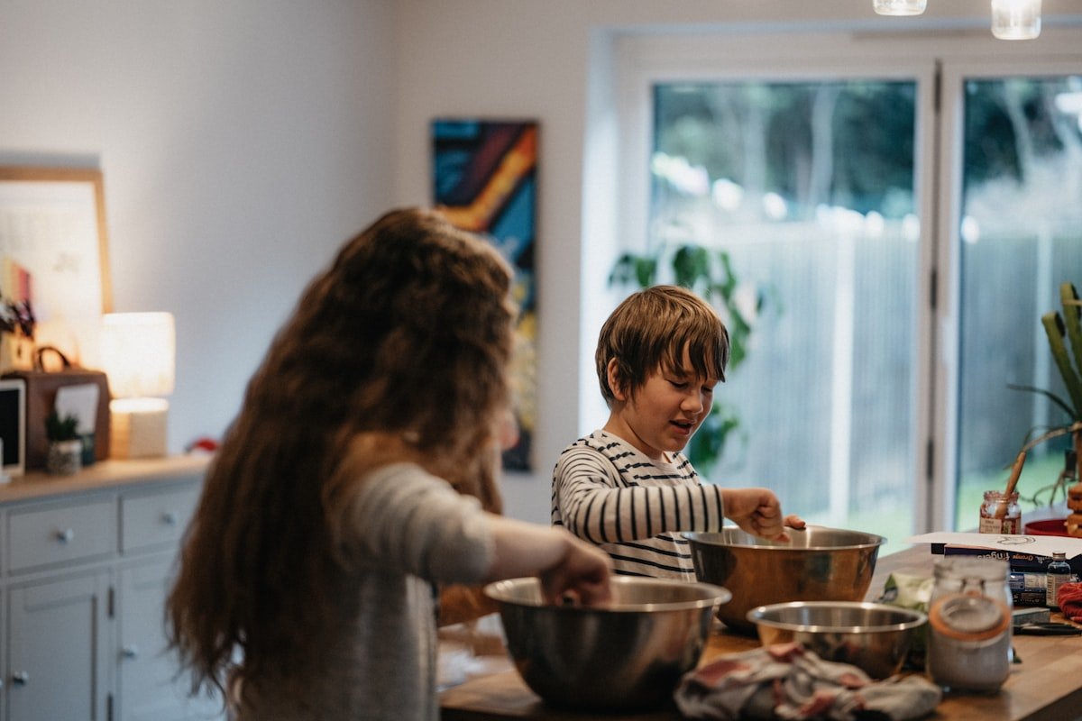 Kids making their own pizzas at the kitchen counter