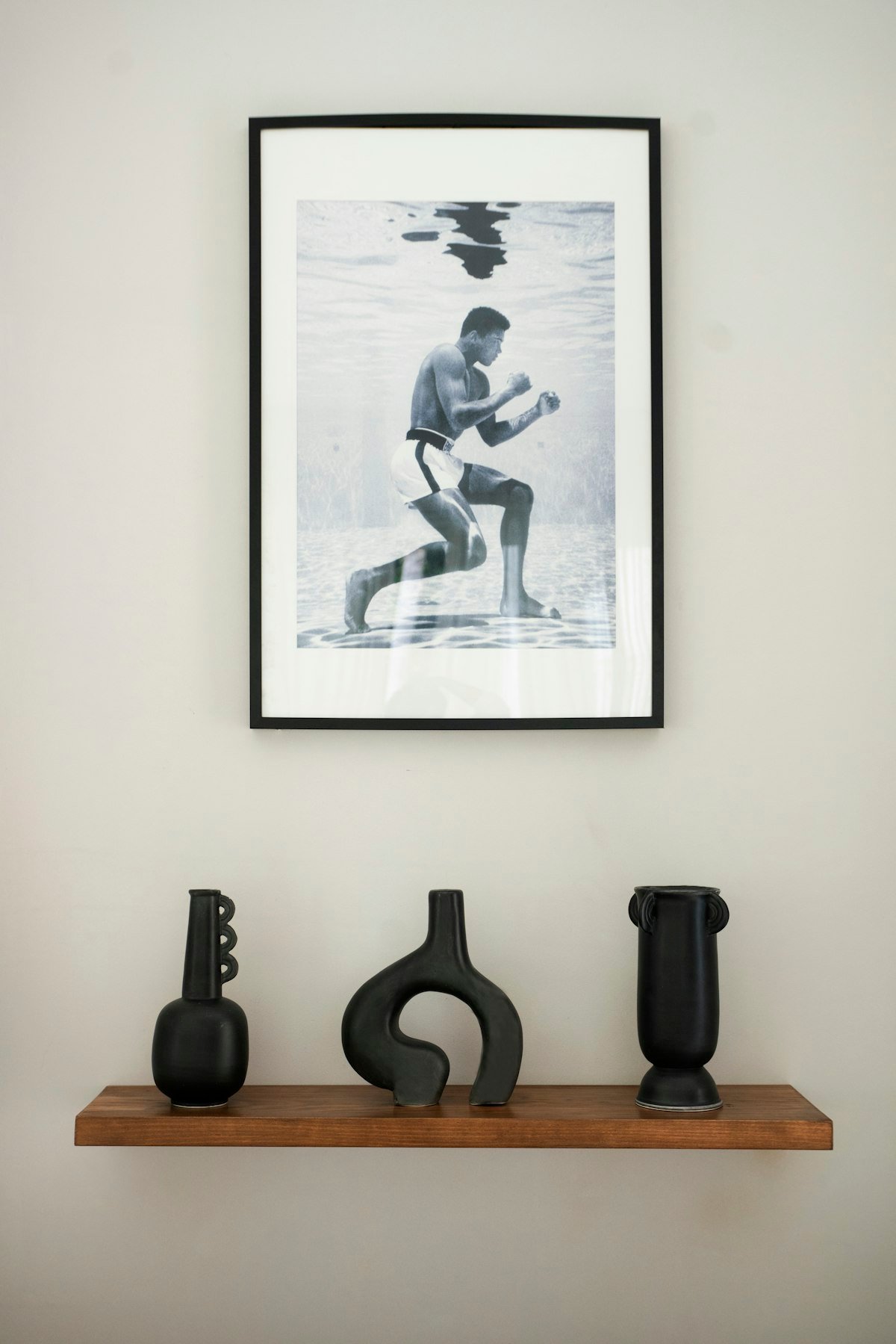 Framed art print leaned and layered with objects on a shelf