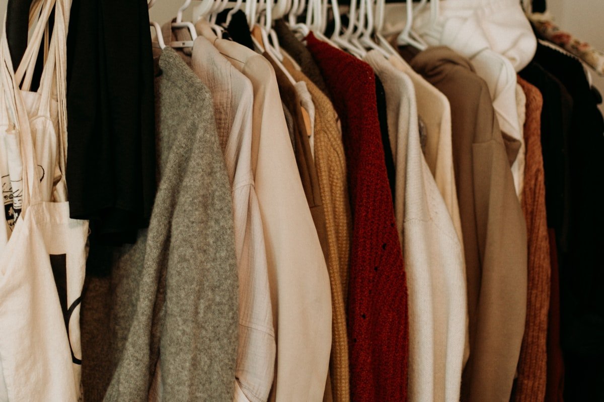 Warm neutral clothes hanging on a tidy closet rack
