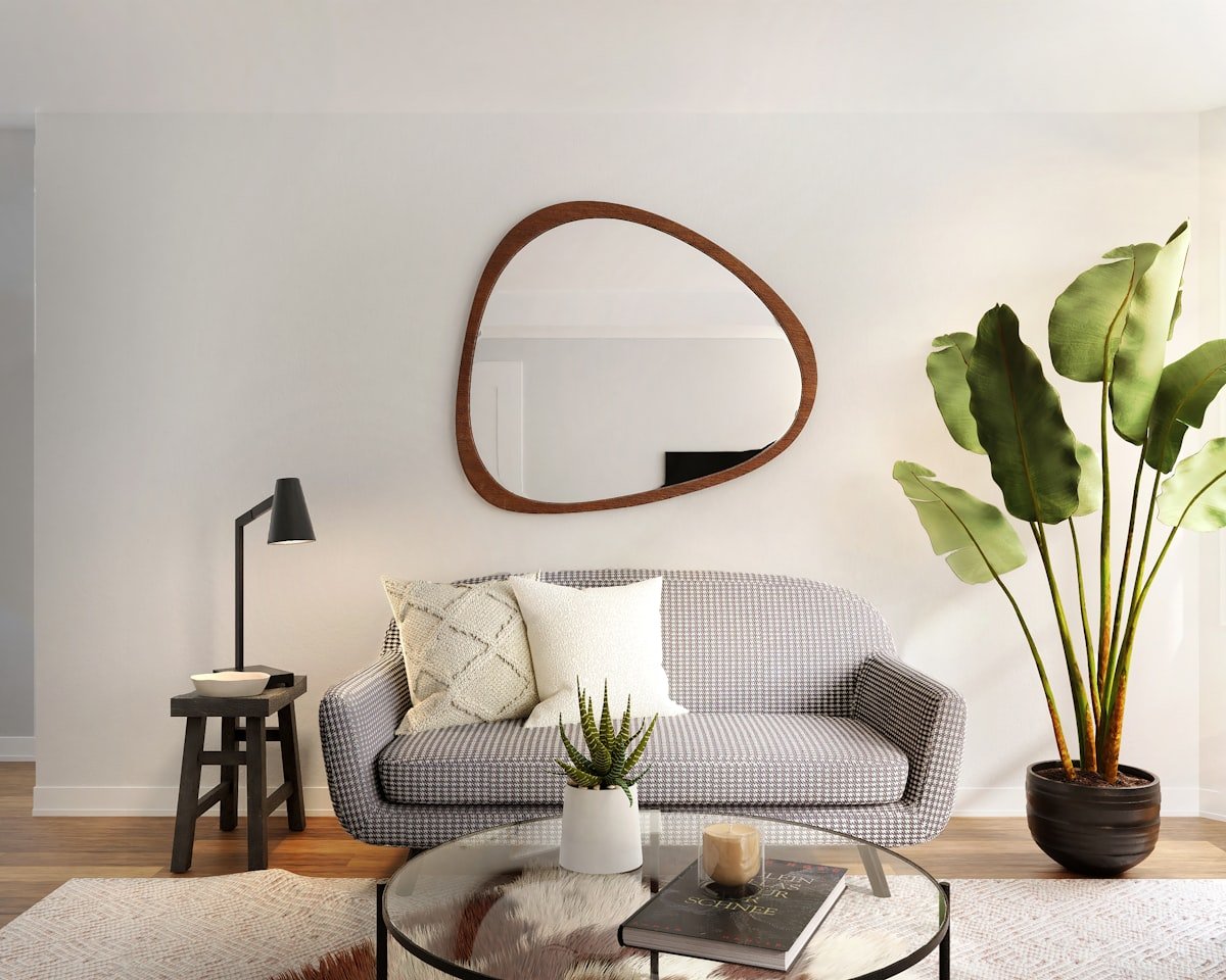 Large organic-shaped mirror hung on a living room wall to bounce light