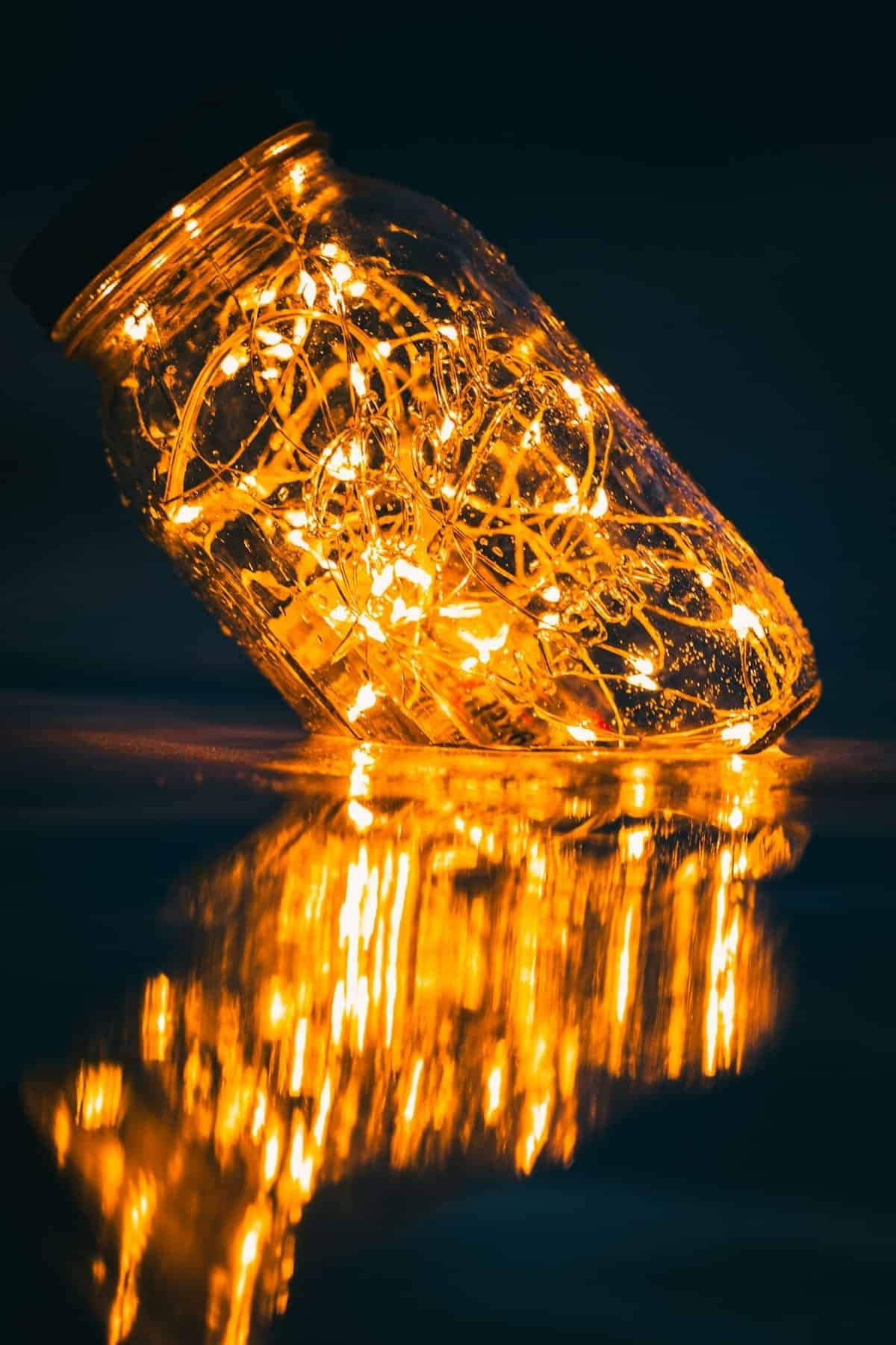 Warm string lights glowing inside a glass jar