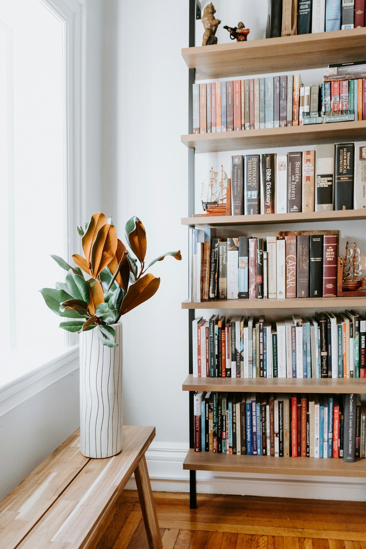 Styled bookshelf with books and a vase of magnolia branches