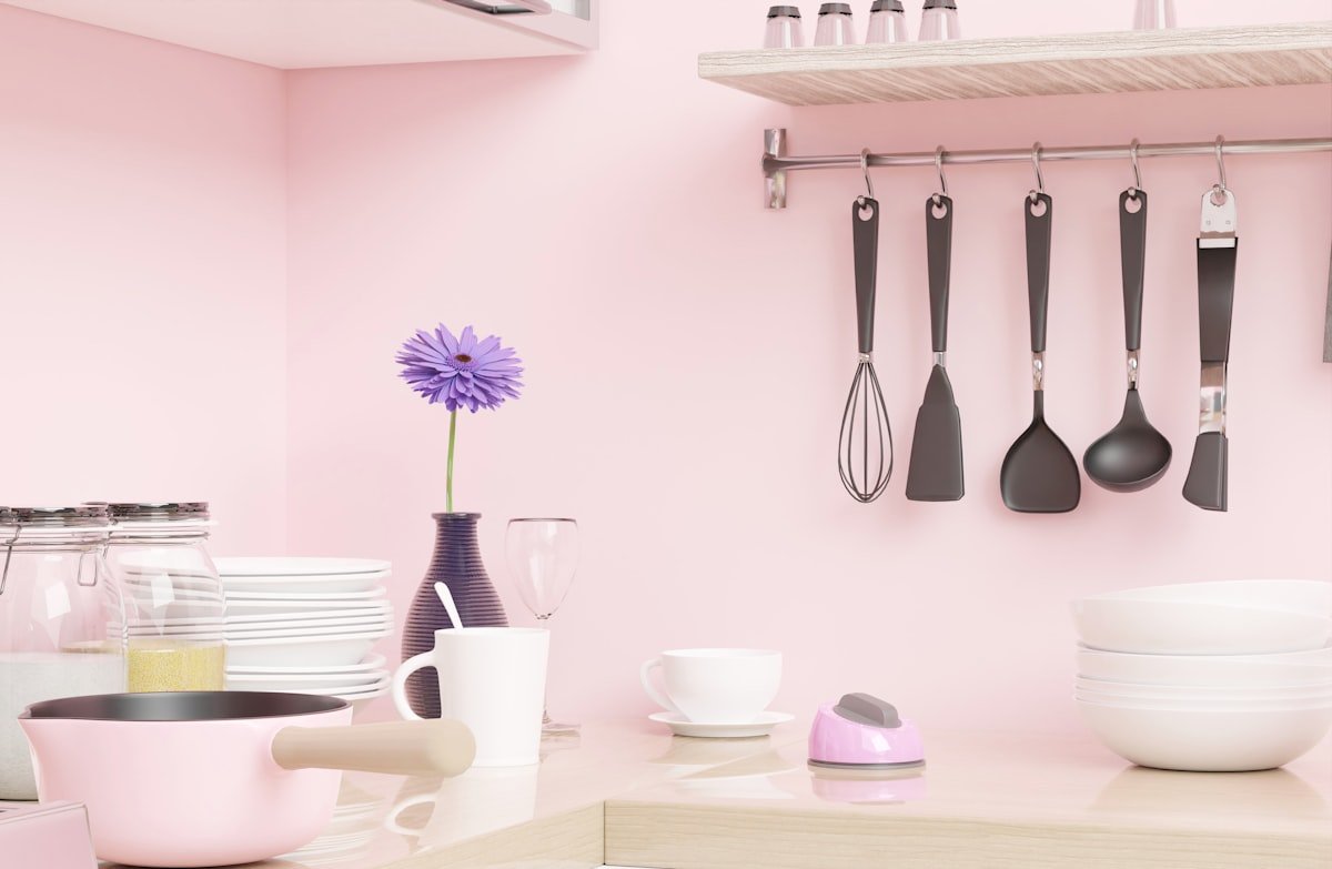 Cooking utensils hanging from a wall rail above the counter