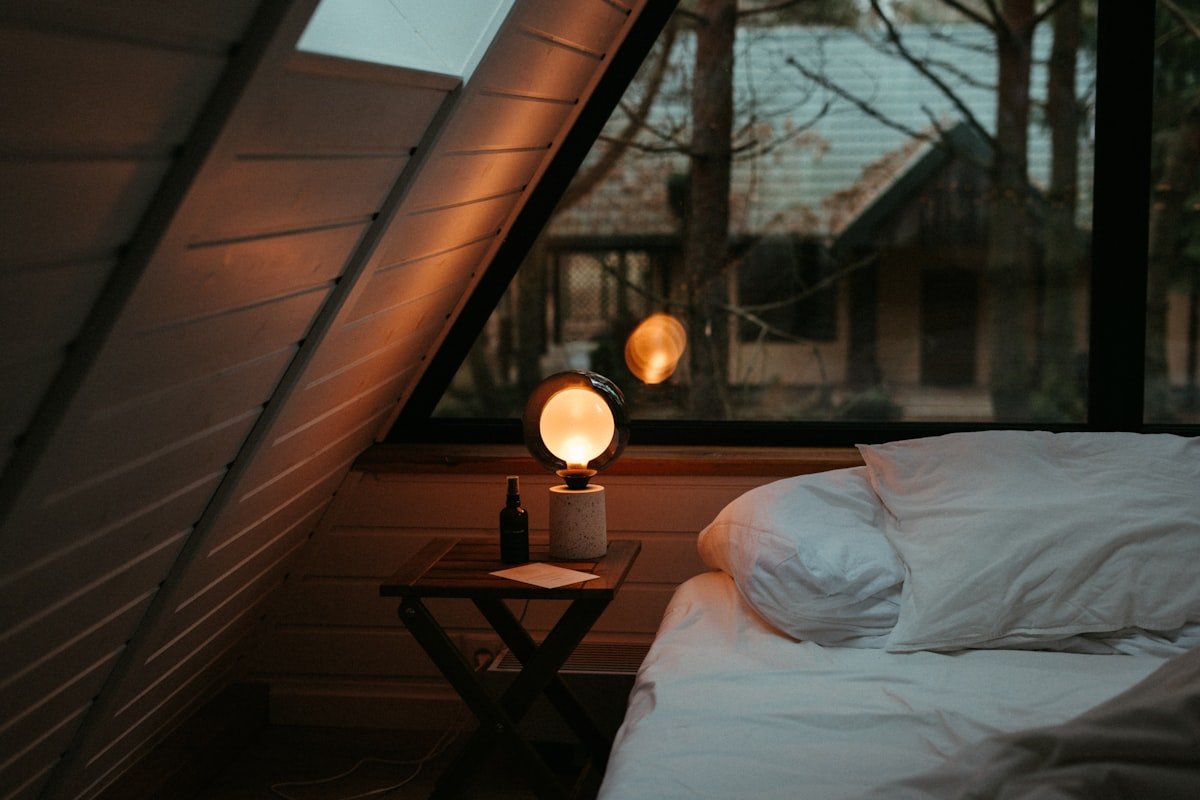 Warm lamp glow making a bedroom corner feel cozy