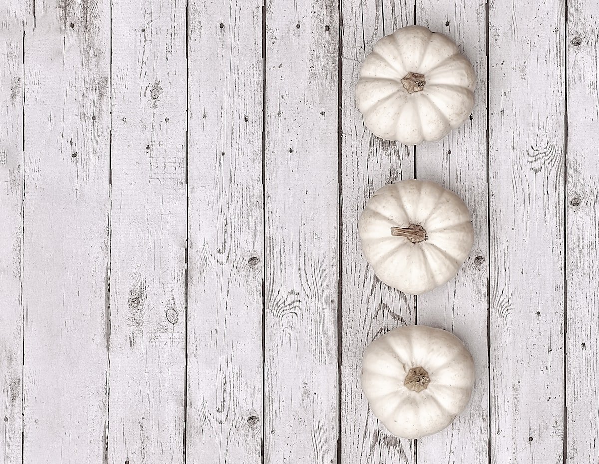 White pumpkins lined up as a simple modern centerpiece