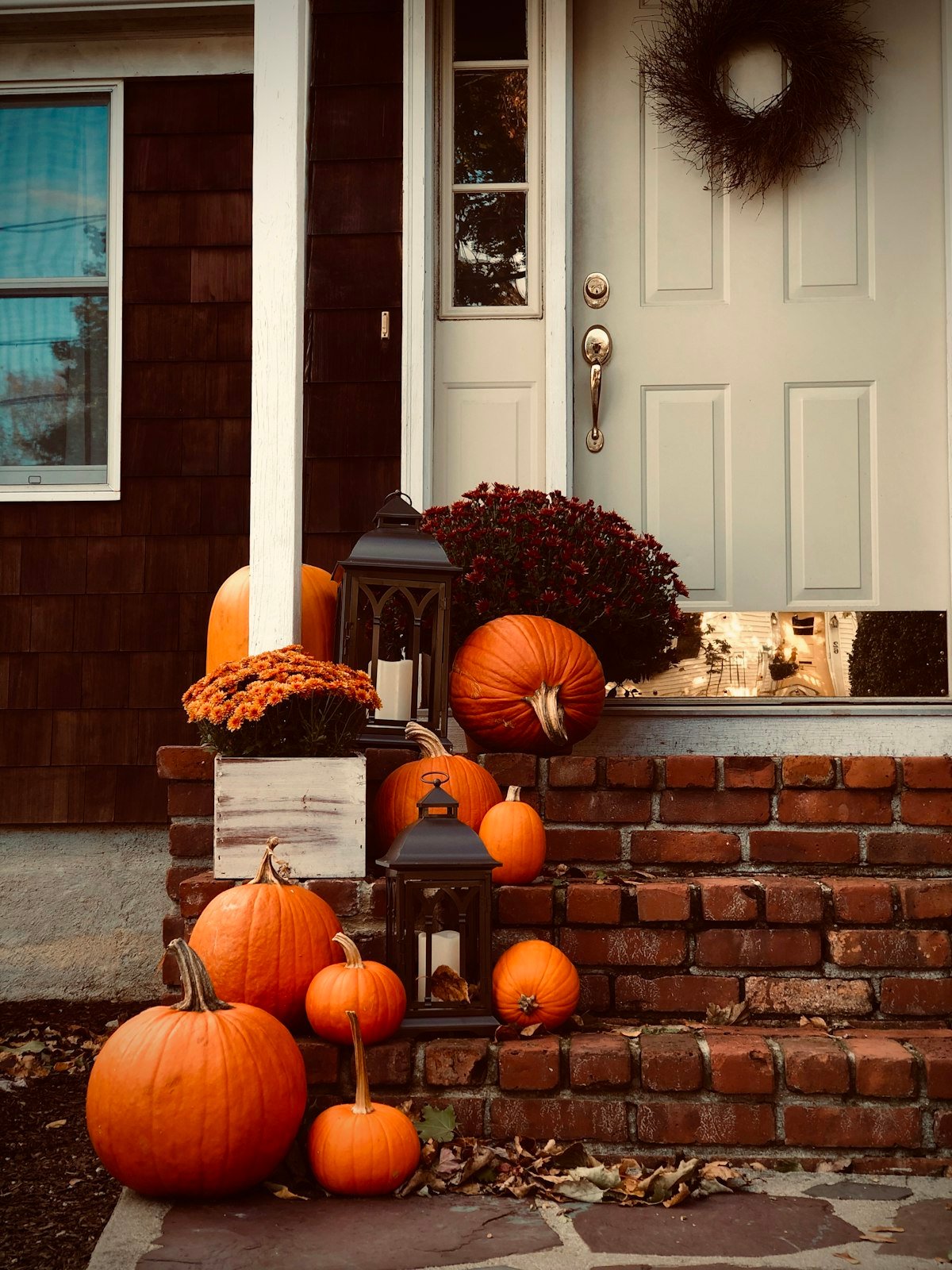 Cozy fall porch with pumpkin cluster, lantern, and mums by the front door